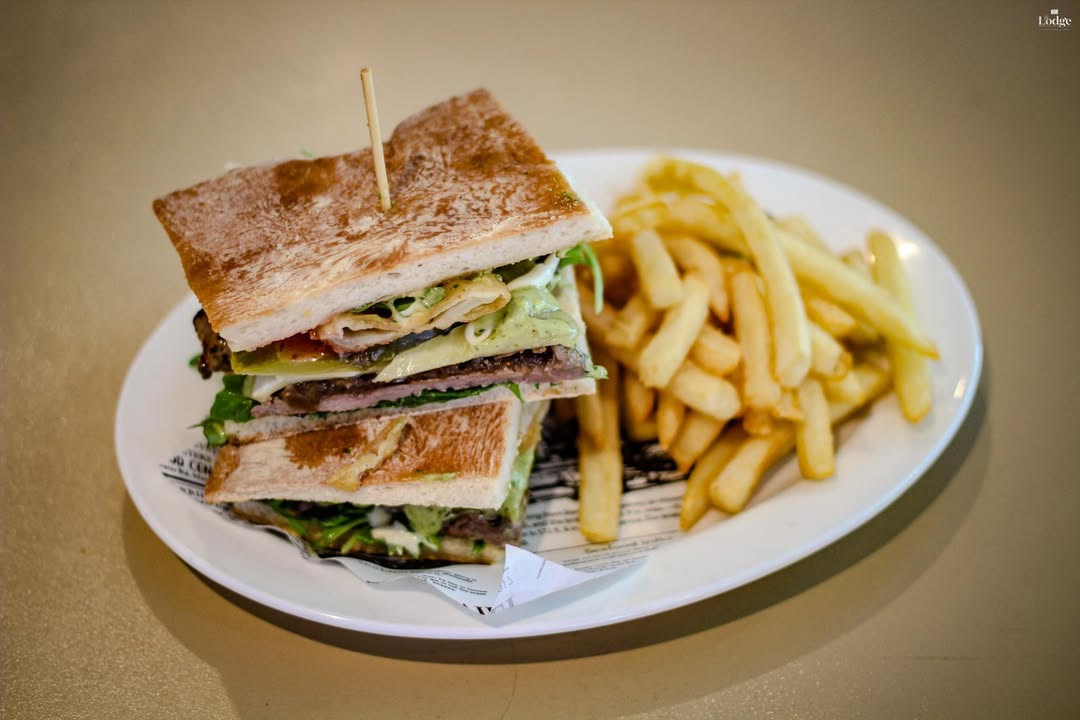 Featured image for “This hearty steak sandwich features tender grilled steak, melted cheese, and a rich, flavorful dressing, layered between perfectly toasted bread. Served with crispy golden fries for a classic, satisfying meal!”